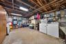 Unfinished lower level featuring exposed joist ceiling, wall-mounted mechanical system, utility sink, and concrete flooring