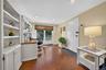 Built-in white cabinetry with open shelving, wood-finish flooring, glass-paned sliding exterior door, and recessed lighting