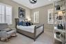 Inviting bedroom with plantation shutters and natural light from multiple windows.