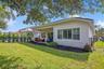 eautifully maintained backyard with lush green lawn, mature landscaping, and attractive fencing.