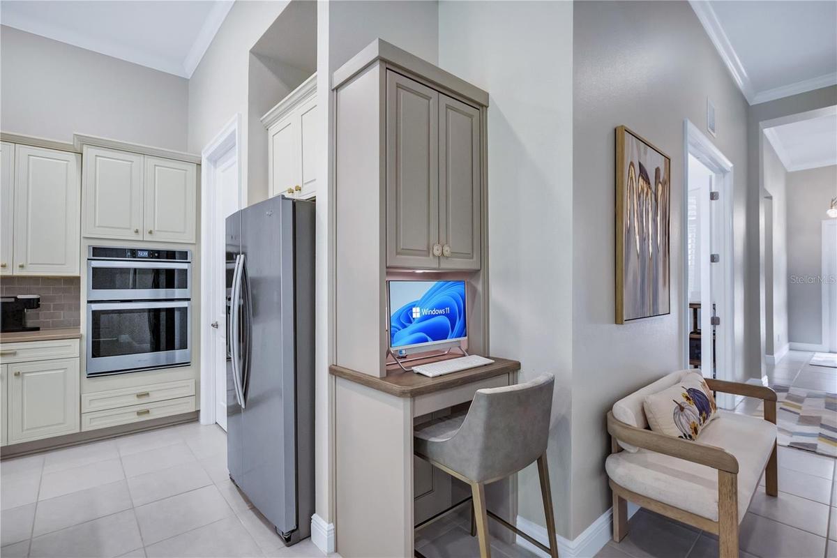 Convenient built-in computer workstation located just off the kitchen, featuring custom cabinetry and a dedicated workspace perfect for everyday tasks