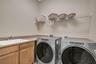 Spacious laundry room with utility sink, cabinetry, and convenient storage.