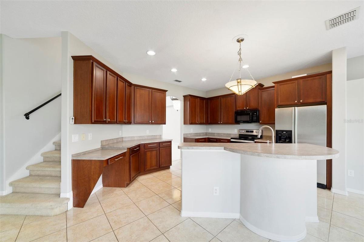 A center island with breakfast bar offers plenty of room for meal preparation and gathering.