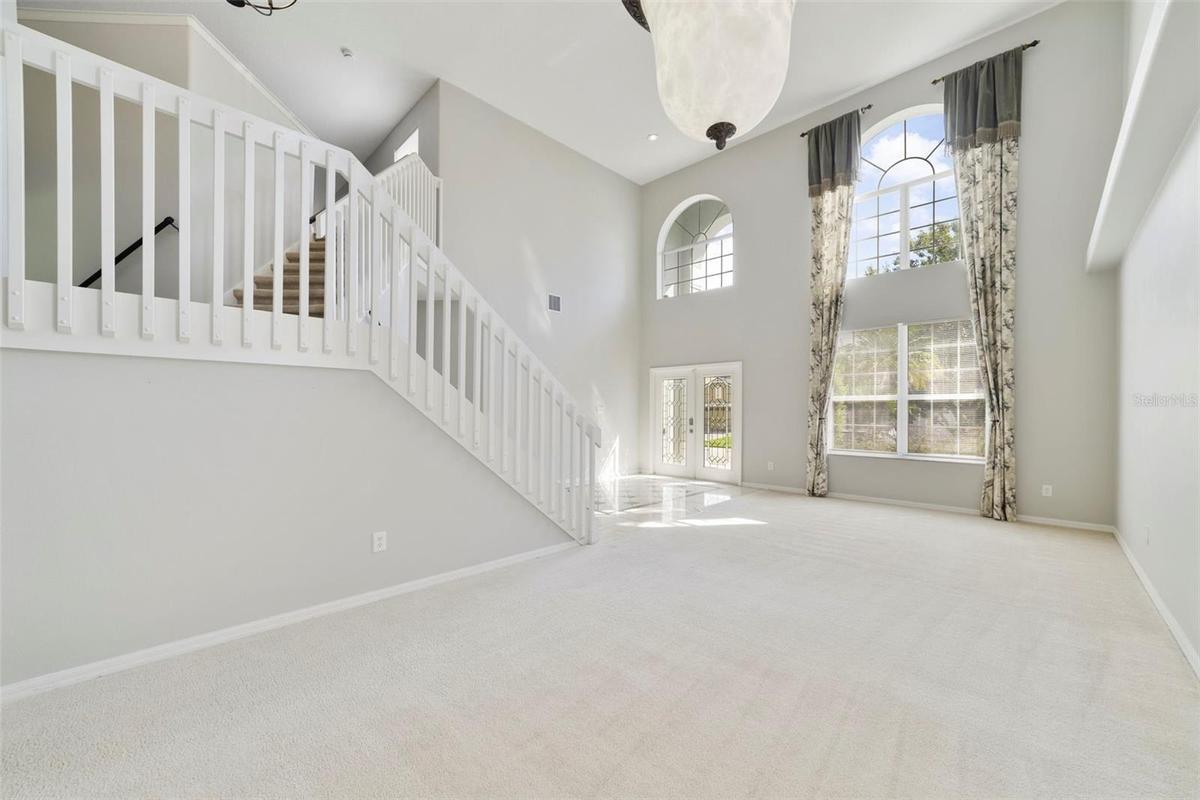 The formal LIVING ROOM/DINING ROOM COMBO share an elegant, open setting enhanced by 2-STORY CEILINGS where a chandelier and decorative ceiling medalli