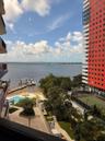 Waterfront setting featuring a private dock, outdoor swimming pool, tennis court, and manicured landscaping
