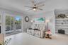 Large-format tile flooring, double glass door with integrated railing, contemporary ceiling fan with light fixture, and built-in wall shelving
