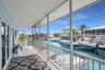 Screened-in balcony featuring tile flooring, metal railings, and direct water canal access
