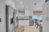 Kitchen featuring white cabinetry, subway tile backsplash, dark solid-surface countertops, recessed lighting, and stainless steel appliances