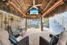 Covered patio featuring a thatched roof, brick paver flooring, ceiling fan, and string lighting