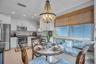 Kitchen featuring white shaker-style cabinetry, stainless steel appliances, subway tile backsplash, recessed lighting, and a built-in banquette seatin