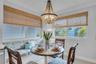 Beaded empire chandelier, custom built-in window seating, and woven wood window shades
