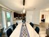 Kitchen featuring dark-toned cabinetry, light-toned stone-surface countertops, and stainless steel appliances, with wood-finish flooring and glass-pan