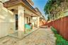Covered patio featuring stone-tiled flooring, built-in masonry fire pit, and privacy wood fencing