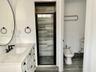 Bathroom featuring a white vanity with a light-toned countertop, undermount sink, matte black widespread faucet, and oval wall-mounted mirror