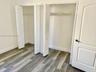 Dual reach-in closets featuring bi-fold doors, white interior finishes, wire shelving, and wood-finish flooring