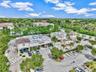 Commercial retail center featuring a paved parking lot, mature palm tree landscaping, and direct street frontage