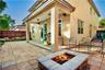 Covered patio with recessed lighting, stone-tiled flooring, and a built-in stone-surround fire pit