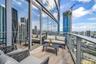 Private balcony featuring wood-finish tile flooring, floor-to-ceiling glass paneling, and a metal railing