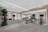 Fitness area featuring recessed ceiling lighting, wall-to-wall mirrors, and durable flooring
