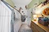 Room featuring light green painted walls, white door with matte black hardware, and wall-mounted wooden shelving