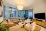 Living area featuring floor-to-ceiling windows, white tile flooring, custom drum pendant lighting, and a sliding glass door providing external access