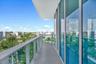 Private balcony featuring a glass-panel railing, floor-to-ceiling windows, and concrete flooring