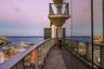 Wraparound balcony featuring glass panel railings, wood-finish flooring, and floor-to-ceiling exterior glazing