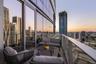 Curved balcony featuring full-height glass-paneled railings, floor-to-ceiling glass exterior wall, and wood-finish decking