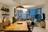 Open-concept interior featuring floor-to-ceiling glass windows, high-gloss tile flooring, built-in wall shelving, and metallic pendant lighting