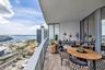 Expansive covered balcony featuring wood-finish flooring and a tempered glass railing