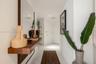 Wall-mounted wooden floating shelf, full-length mirror, recessed ceiling lighting, and polished stone-finish floor tile
