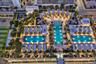 Elevated outdoor amenity deck featuring three swimming pools, landscaped terrace areas with mature palm trees, and multiple private cabana structures