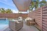 Swimming pool with water feature, composite decking, horizontal wood privacy fencing, and an overhead fabric shade canopy