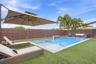 Backyard featuring a rectangular swimming pool with an integrated spa, horizontal slat privacy fencing, artificial turf, and a water feature
