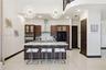 Kitchen featuring dark wood-finish cabinetry, a white stone island countertop, a stainless steel chimney-style range hood, recessed ceiling lighting, 