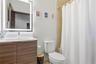 Bathroom vanity featuring a wood-finish cabinet, integrated countertop, and LED-backlit mirror