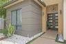 Modern exterior facade featuring smooth stucco finishes, horizontal architectural detailing, double-entry door with glass panels, geometric metal pend