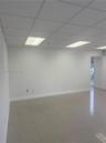 Neutral-toned ceramic tile flooring, drop ceiling with recessed rectangular lighting, and smooth-finished walls
