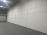 Industrial space featuring high ceilings, painted masonry walls, concrete flooring, and a metal roll-up overhead door