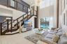 Double-height living area featuring large-format tile flooring, a custom staircase with dark wood-finish treads and a horizontal cable railing system,