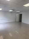Open interior space featuring light-toned tile flooring, a drop ceiling, recessed panel lighting, and a single hinged door
