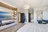 Custom built-in media center with vertical slat wood accent wall, integrated LED display shelving, recessed tray ceiling, contemporary crystal chandel