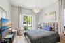 High-ceilinged room featuring oversized window panels, glossy tile flooring, and a crystal-accented chandelier fixture