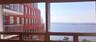 Large multi-pane window with metal frames, expansive water horizon, and bridge backdrop
