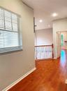 Interior space featuring wood-finish flooring, recessed lighting, and a metal balustrade railing