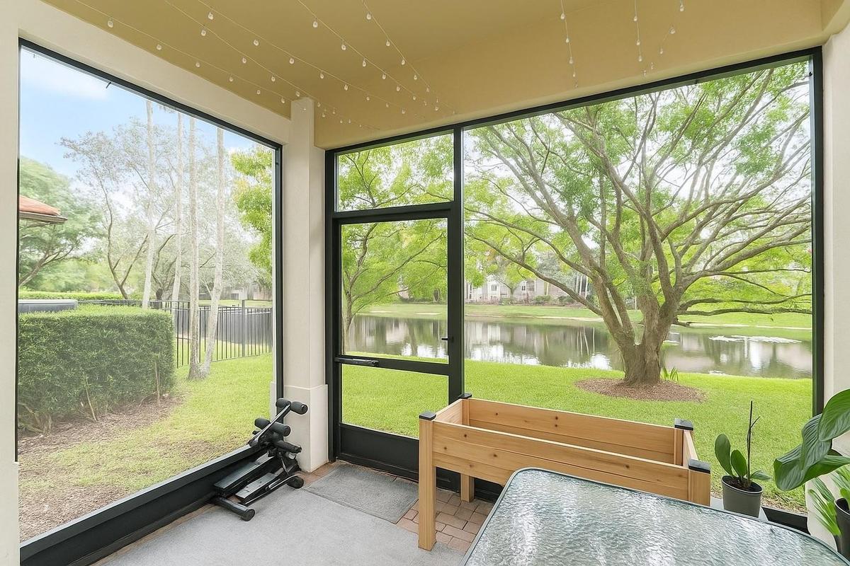 Screened-in patio featuring floor-to-ceiling window panels, black metal framing, a dedicated screen door, concrete flooring, and water frontage