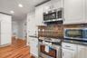 Kitchen range and cabinetry with hallway view