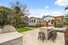 Outdoor kitchen with bar seating and view of the rear exterior