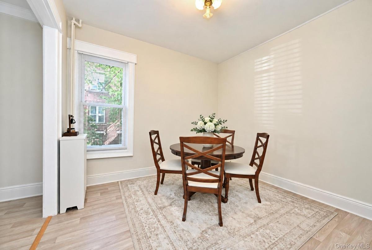 1st Floor: Neutral-toned walls, wood-finish flooring, a double-hung window, and a metal radiator enclosure