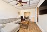 2nd. Floor: Room featuring wood-finish flooring, a suspended grid ceiling, a ceiling fan with integrated lighting, and an arched entryway